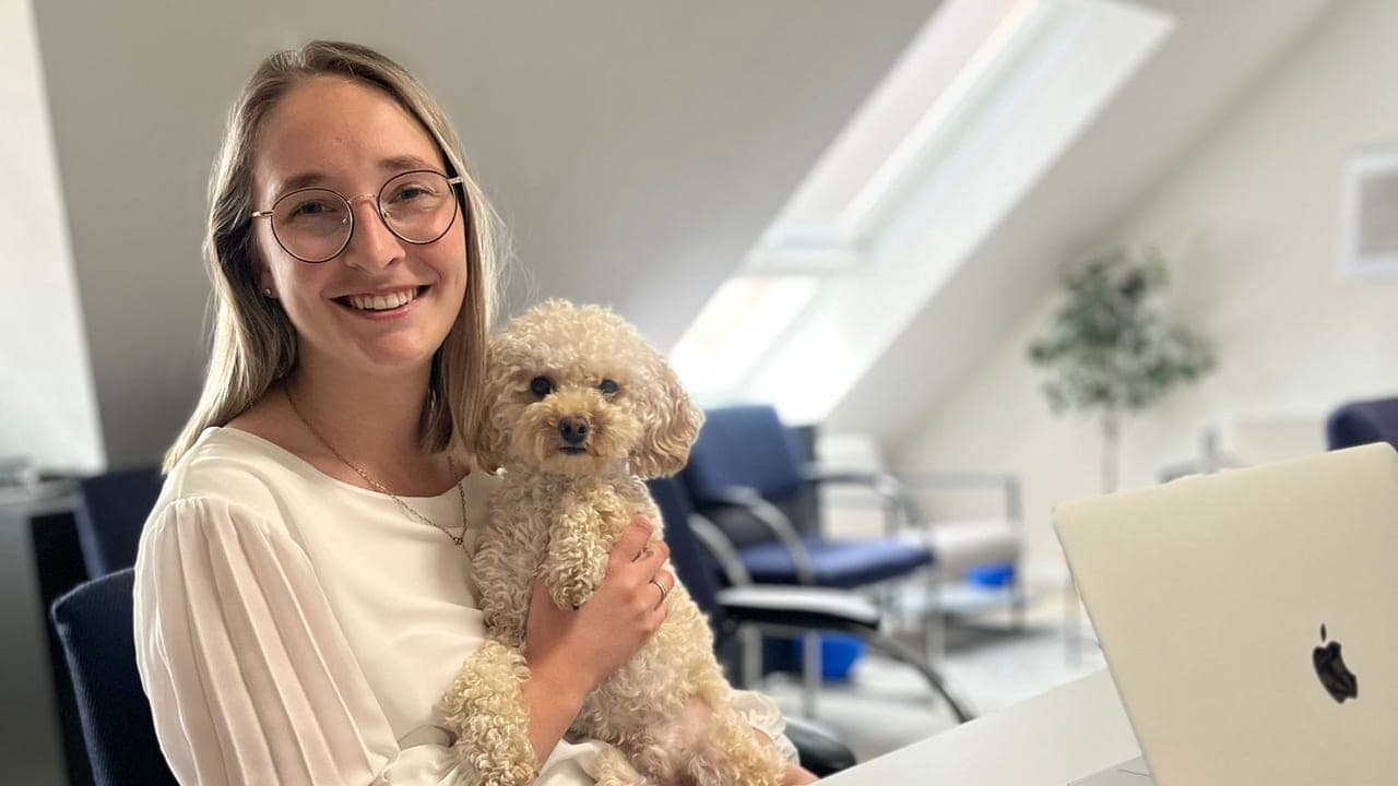 Nino, der Feel-Good-Manager von Zuversichtsberatung, auf dem Schoß einer Mitarbeiterin im Mainzer Büro