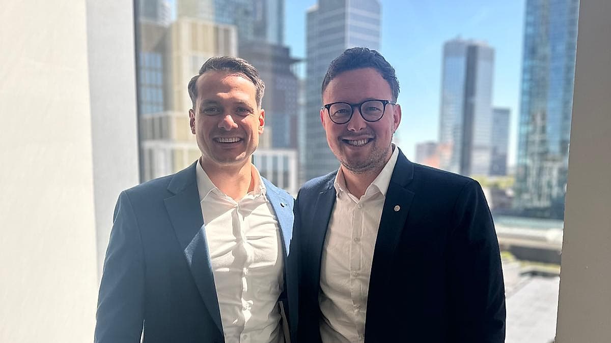 Tim Fialkowski (rechts) zu Besuch bei der DWS Group in Frankfurt vor der Frankfurter Skyline